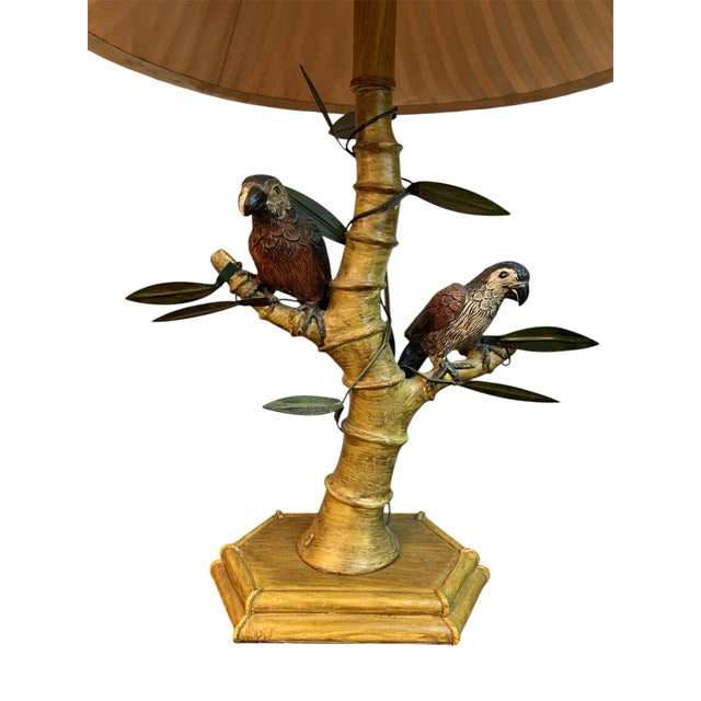 Rare, hand painted, parrot adorned table lamp. Has a bamboo shade with a rose gold interior fabric. Lamp stands 27” tall...