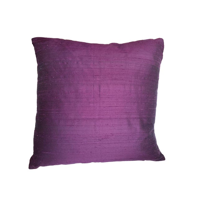 This pillow features a deep purple fabric with a colorful, striped border frames the pillow, adding a pop of contrasting...
