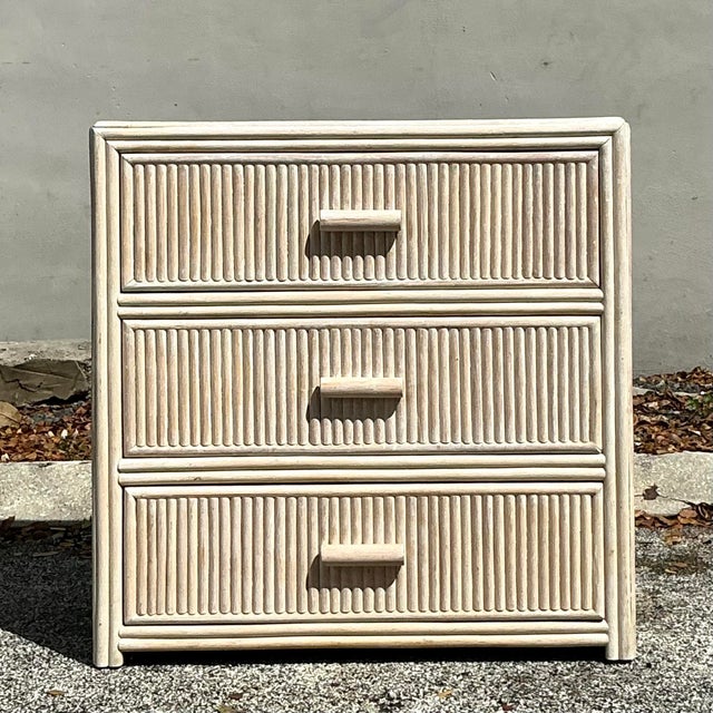 This vintage coastal chest of drawers features a washed rattan finish, blending beachy charm with practical storage. Its...