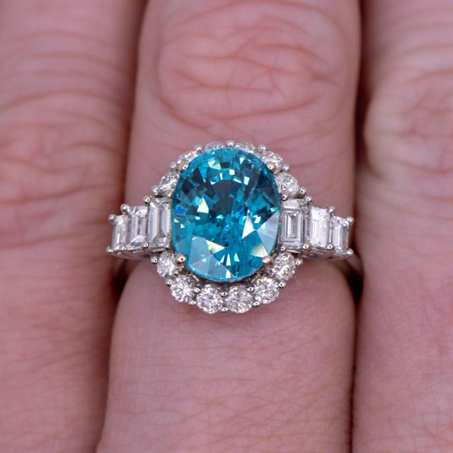 A blue zircon takes centre stage in a brilliant electric blue at the centre of this solid 14K white gold ring, encircled...