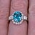 A blue zircon takes centre stage in a brilliant electric blue at the centre of this solid 14K white gold ring, encircled...