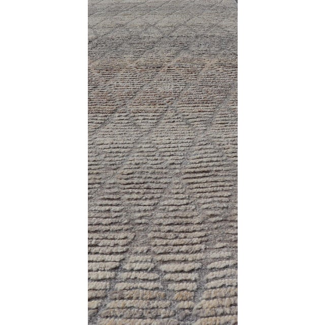 Measures: 2'9 x 9'5. This modern casual tribal rug has been hand-knotted in wool. The rug features a modern geometric...