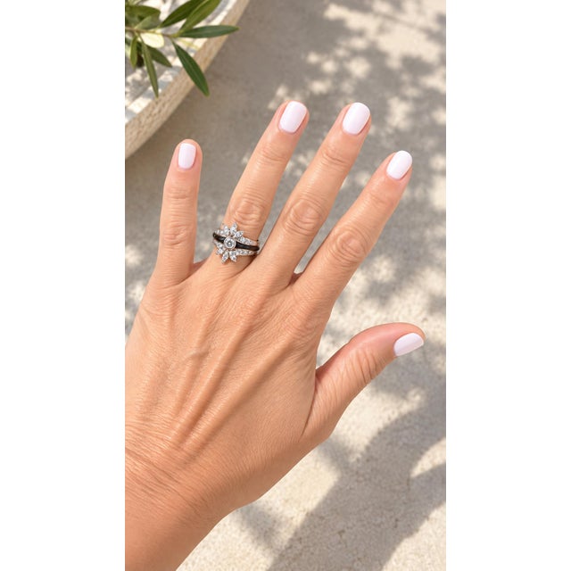 A Mid-Century platinum ring featuring a dramatic starburst of diamonds accented by a sleek black onyx inlay. At the center...