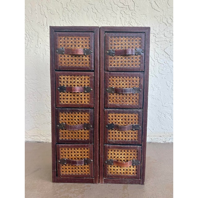 Unique pair of vintage circa 1980s tall apothecary-style chests crafted from woven cane and rattan with richly aged...