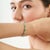 This elegant infinity link bracelet features 14 natural oval-cut emeralds totaling 6.76 carats, accented with 0.30 carats...
