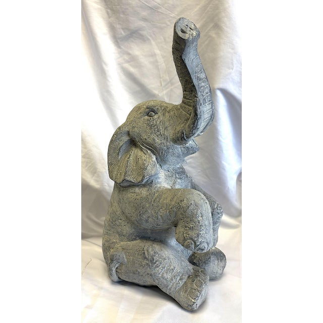 Adorable vintage elephant statue from the late 20th century. The sitting elephant has an uplifted trunk symbolizing good...