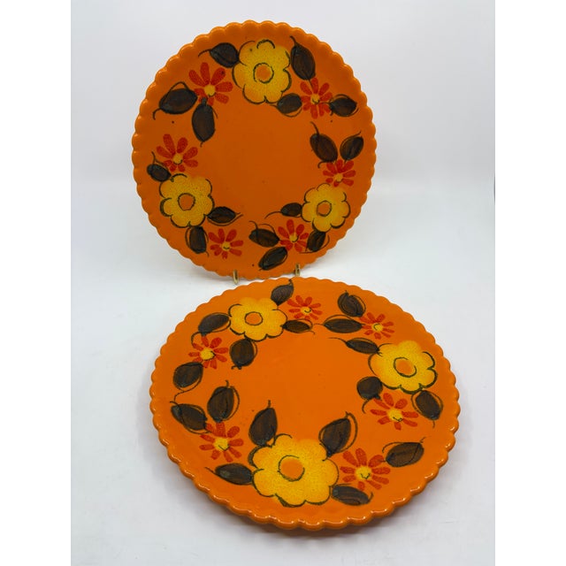 Vintage 1960-1970s era ceramic scalloped dinner plates. Bright orange plates with yellow and orange florals. The plates...