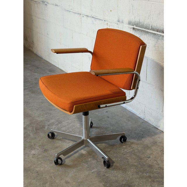 This ergonomic swivel office desk chair features a bentwood shell back with padded seating and chrome armrests. Its five-...