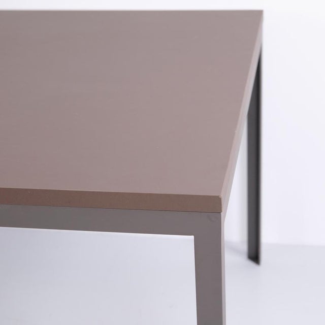 Danish design dining table made with steel legs and a tabletop with a grey linoleum surface. The table has a simple and...
