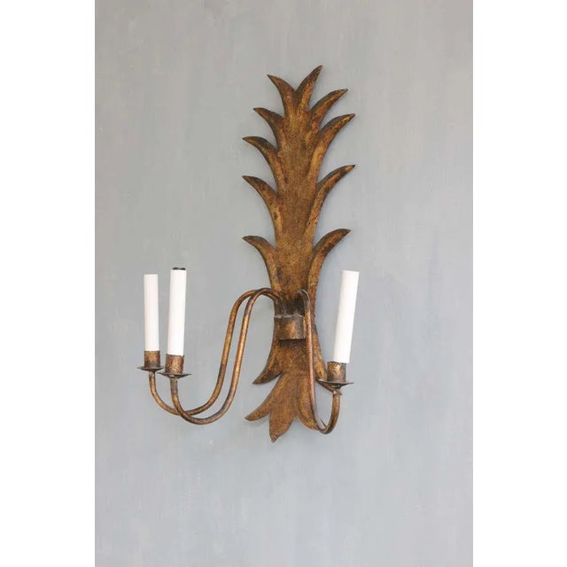 An unusual 1950s Spanish gilt metal three-arm sconce wired for candelabra bulbs. This large Spanish gilt metal sconce is a...