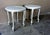 This is a pair of Hollywood regency tables from the 1970s. The pieces feature marble tops and silver leafed, twisted rope...