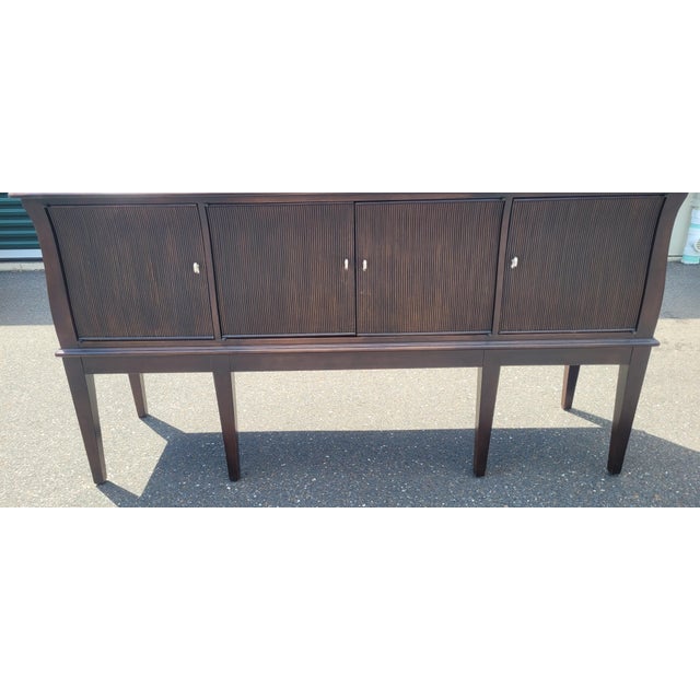 Find stylish modern sideboard by Lexington. Features three compartments with shelves, thin band inlaid in the top, ribbed...