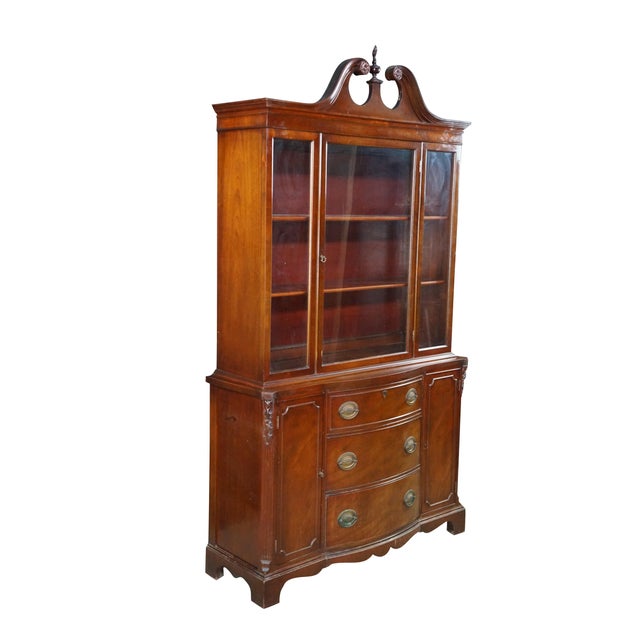 This mid-century Sheraton and Federal-inspired mahogany china cabinet beautifully blends classic early American...