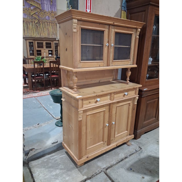 A charming antique European pine kitchen dresser or food cupboard dating from the late 19th to early 20th century. Crafted...