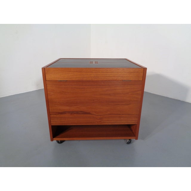 A fold-out, wheeled teak bar from the 1960s by Randers Møbelfabrik. Features a bottle rack and storage space inside the...
