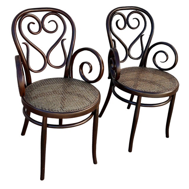 Pair ofVictorian Thonet number 04 armchairs each features an elegant, sculptural frame crafted from warm-toned bentwood...
