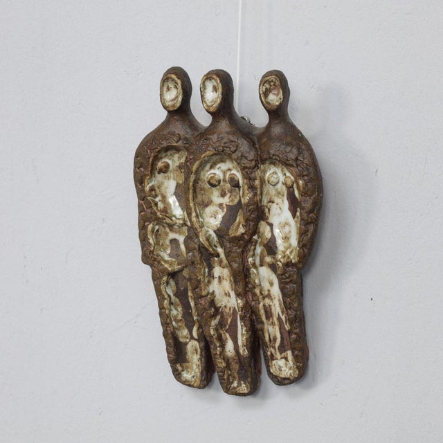 This expressive Brutalist ceramic wall relief from the 1970s depicts three stylized human figures arranged in a vertical...
