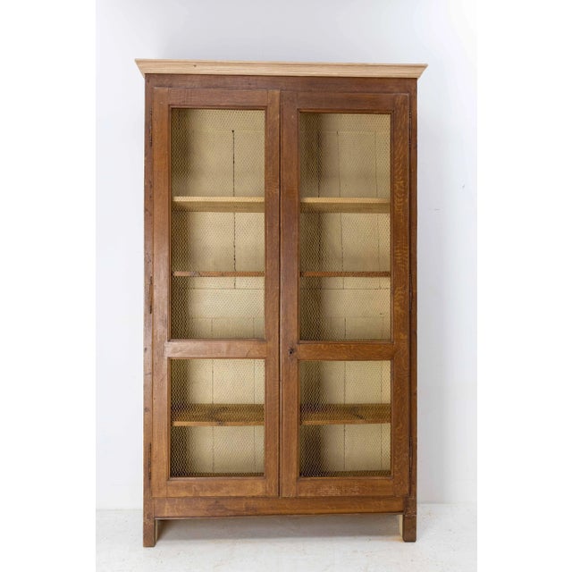 Pine Bookcase with two brass mesh doors. The mesh is handmade with brass wire. This item has a patina in the oak style....