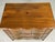 A French Provincial style fruitwood commode or chest of drawers in a rich warm brown tone with visible grain and figuring,...
