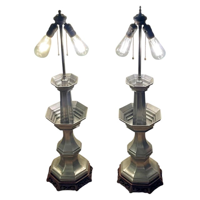 An elegant pair of vintage pewter candlestick table lamps featuring sculptural, baluster-form bodies mounted on...
