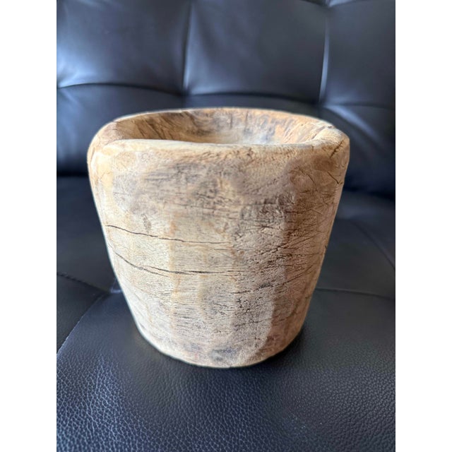 Striking hand-carved wood vessel with an exceptionally weathered, organic character. The surface is richly marked by...