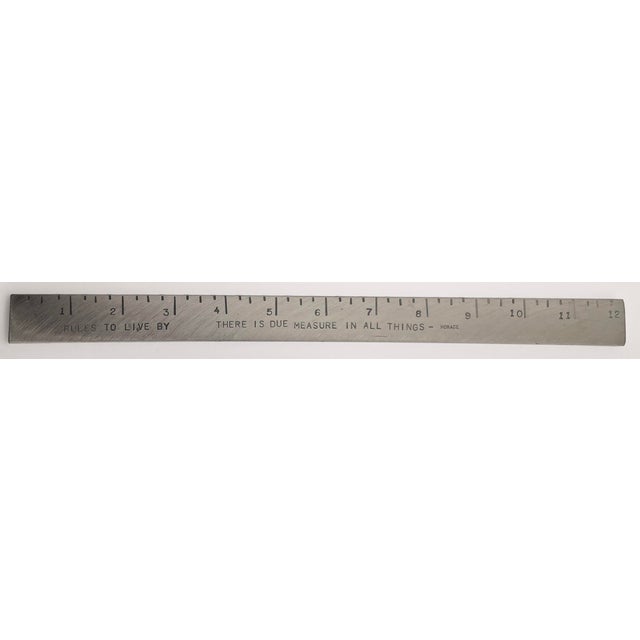 A heavy stainless ruler with the embossed words “RULES TO LIVE BY” and a quote “THERE IS DUE MEASURE IN ALL THINGS” by...