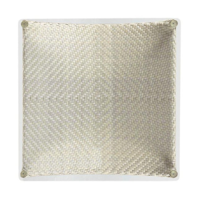 A square tempered glass top rests over four round posts that are enveloped in intricately handwoven synthetic fiber.