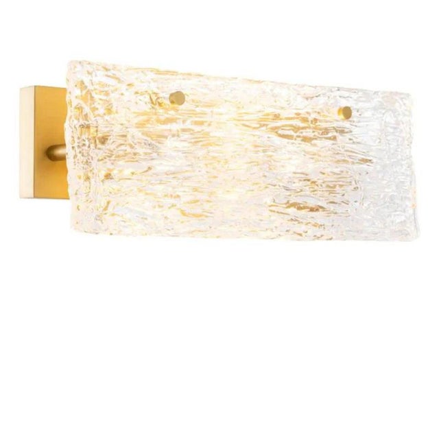 This pair of wall lamp is a contemporary horizontal lamp in antique brass and handmade glass. Its rectangular glass...