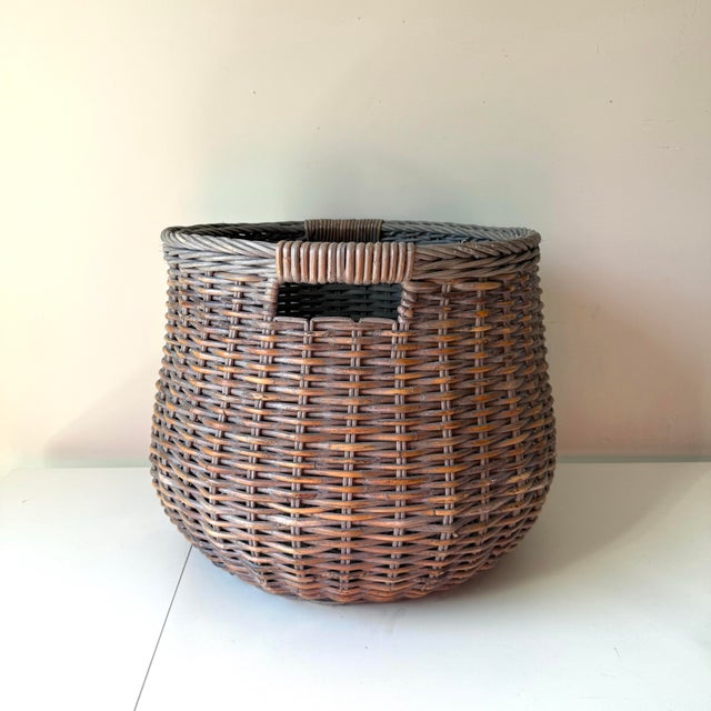 Vintage large woven blanket basket in a stone wash finish over the darker fibers. The basket has two handle slots on...