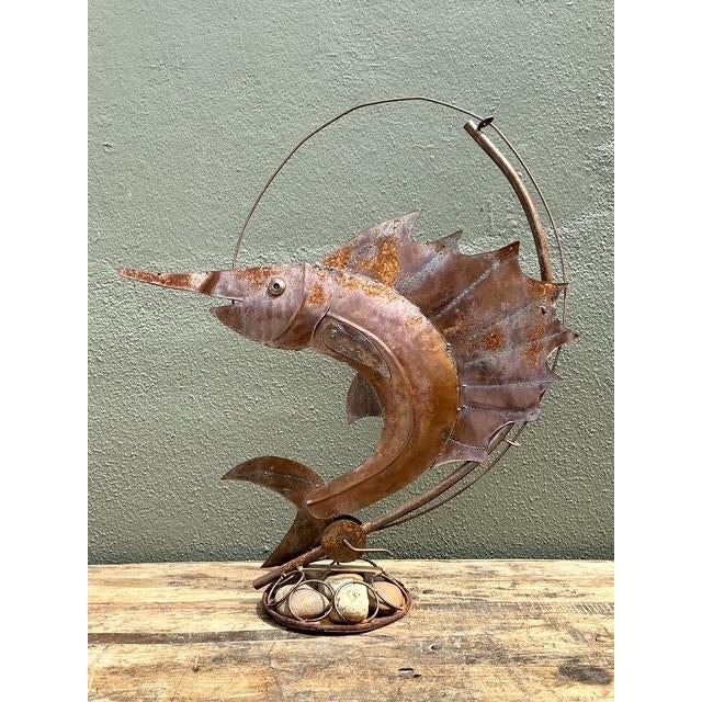 This captivating vintage sailfish sculpture is a masterful expression of coastal folk art, capturing the raw power and...