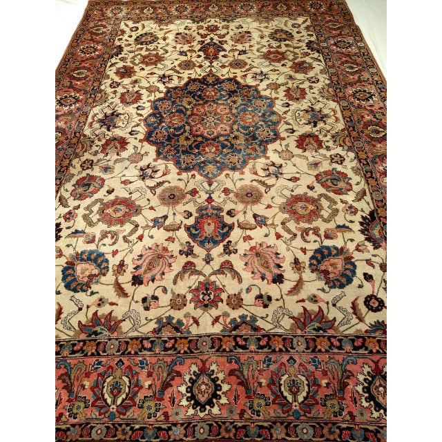 "An early 20th-century Persian Tabriz rug, room-sized and richly adorned with a grand botanical design reminiscent of...