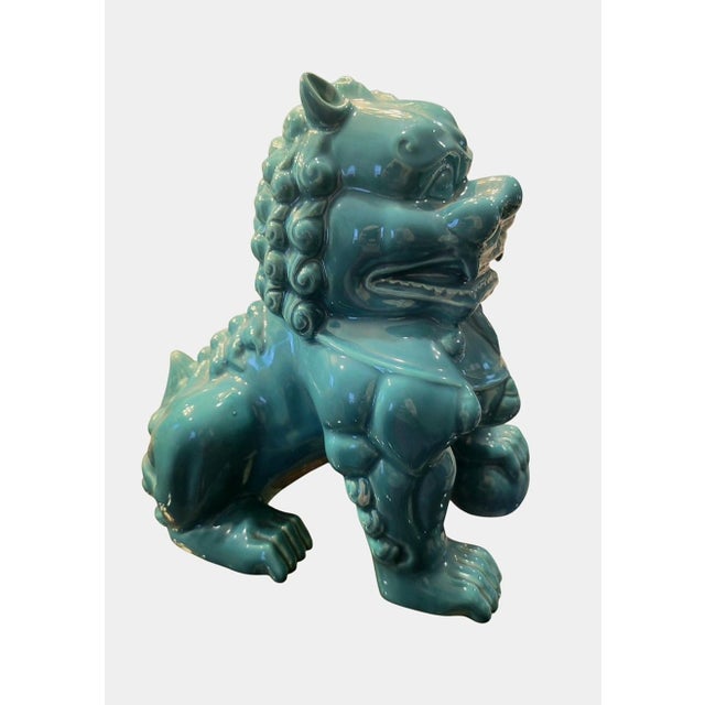 A sweet bright teal blue ceramic foo dog statue. The statue has pretty carved details with a sweet face in a great teal...