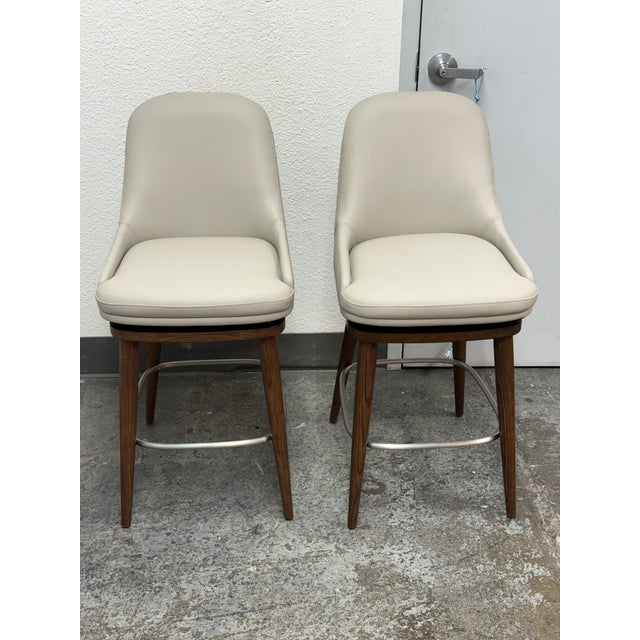 Design Plus Gallery presents a Pair of Harper Swivel Counter Stools from Interlude Home. Each counter stool pairs a walnut...