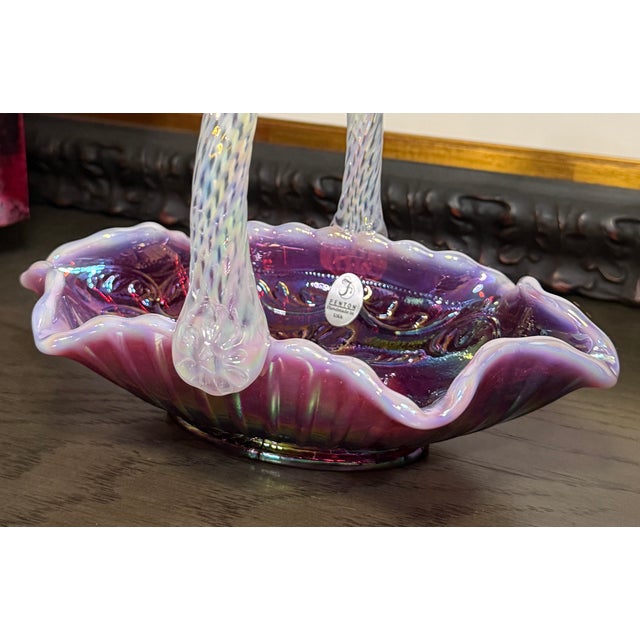 Handmade Fenton plum opalescent carnival glass basket featuring a twisted opalescent handle and richly iridescent finish....