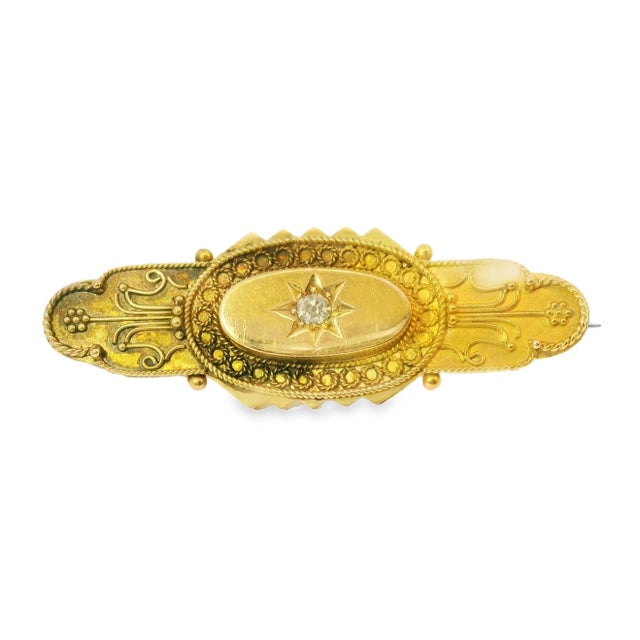This elegant antique bar pin brooch is crafted in 15K yellow gold and features a classic old miner cut diamond at its...