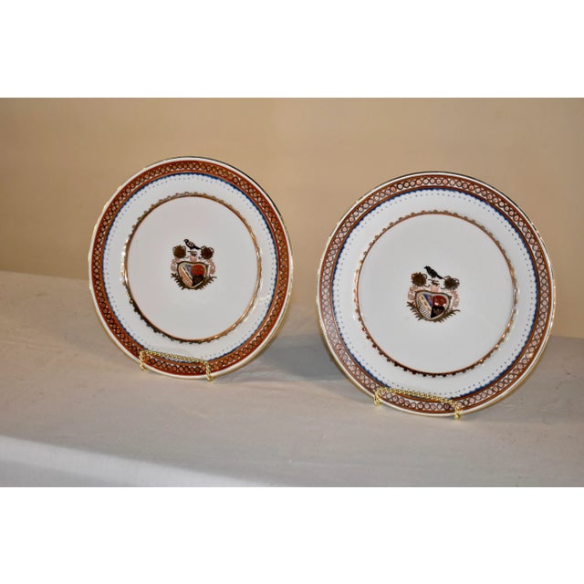 Pair of lovely late 19th century armorial plates from England. The borders are decorated in brick red, gold, and navy. The...