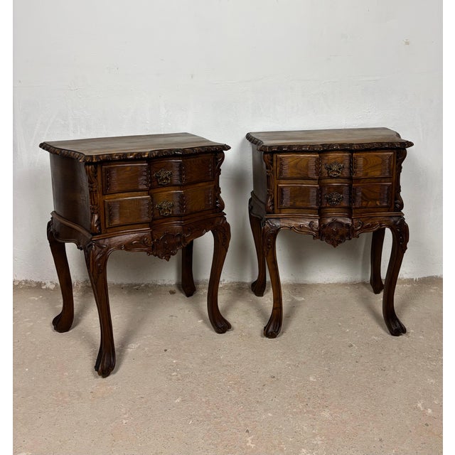 Elegant pair of Spanish Louis XV style bedside tables crafted in oak with richly carved decorative details and graceful...