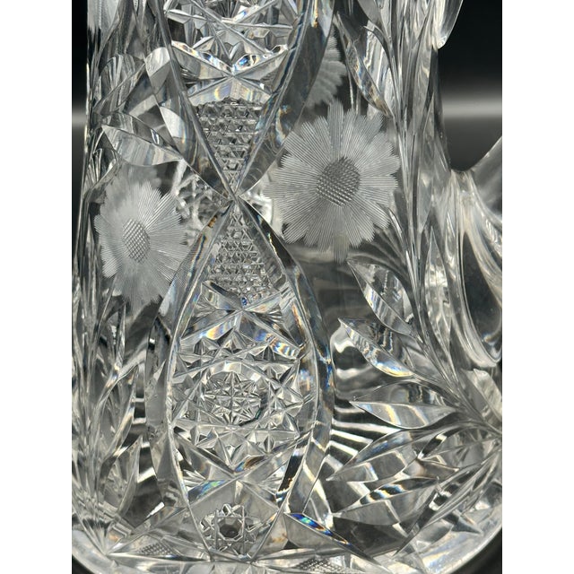 A stunning American Brilliant Period cut glass water pitcher featuring deeply wheel cut hobstars, fans, crosshatching, and...