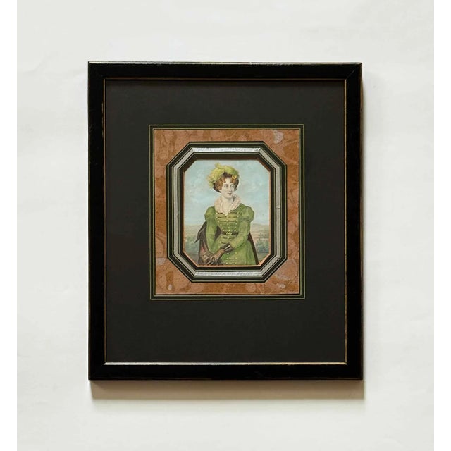 Pair of antique portrait etchings. Hand-colored depictions of a man and a woman in 19th-century attire. Presented in black...