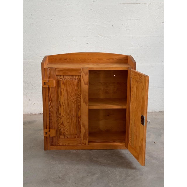 A quietly elegant vintage wall cabinet crafted from pine, dating to the second half of the 20th century. Its clean...