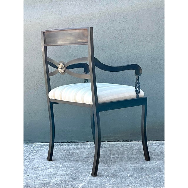 This elegant vintage armchair is a masterful blend of Neoclassical influence and artisanal metalwork. Crafted from...