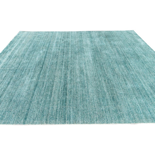 Beautiful modern handmade Indian bamboo and silk boho rug with a teal and ivory field. This Boho collection rug has an...