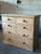 An understated scrubbed pine English chest of drawers. Late 19th Century, with two over three drawers, each with mushroom...