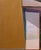This oil on canvas work presents a quiet moment of interaction between figures set against a simplified architectural...