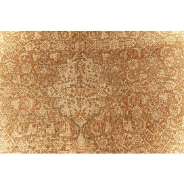 A fine example from our collection of early 20th century Persian Tabriz rugs, the abrashed light reddish brown with a fine...