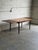 This exceptional expandable dining table features a clean rectangular top supported by slender tapered legs. Two...