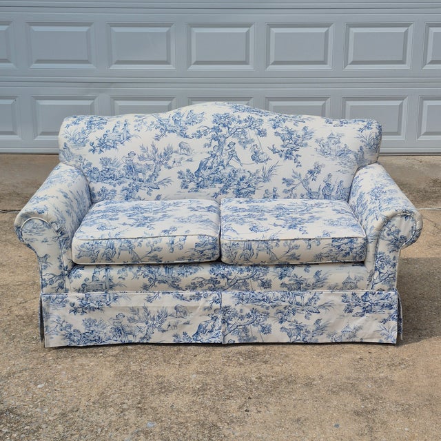 This is a lovely early 20th century camel back loveseat with newer blue and white toile de jouy upholstery. The loveseat...