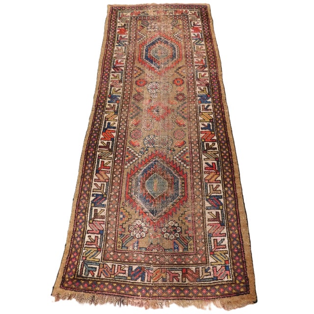 two Serrated geometric medallions on a camel hair background. Ivory border decorated with geometric motifs.