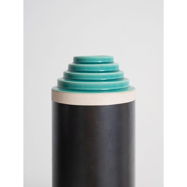 A vase from the stepped series in hand-turned in white clay enameled with two-tone matt gray and light green glaze,...