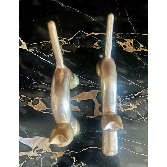 Pair of vintage solid brass cat figurines. Featuring classic mid-century modern minimalist lines, one cat is caught in a...